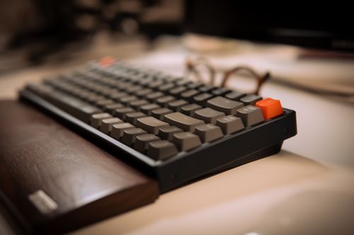 A keyboard with a wooden wrist rest